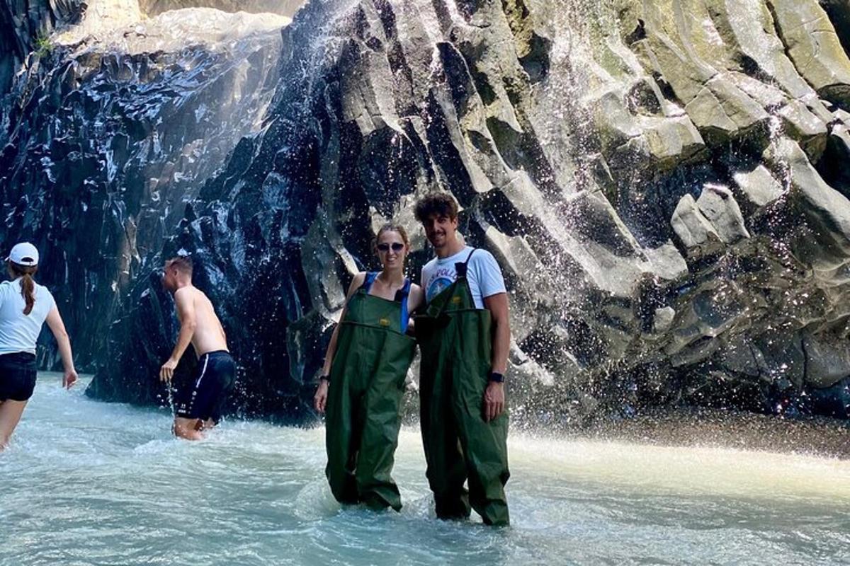 Un grupo de personas de pie en el agua en una cascada.