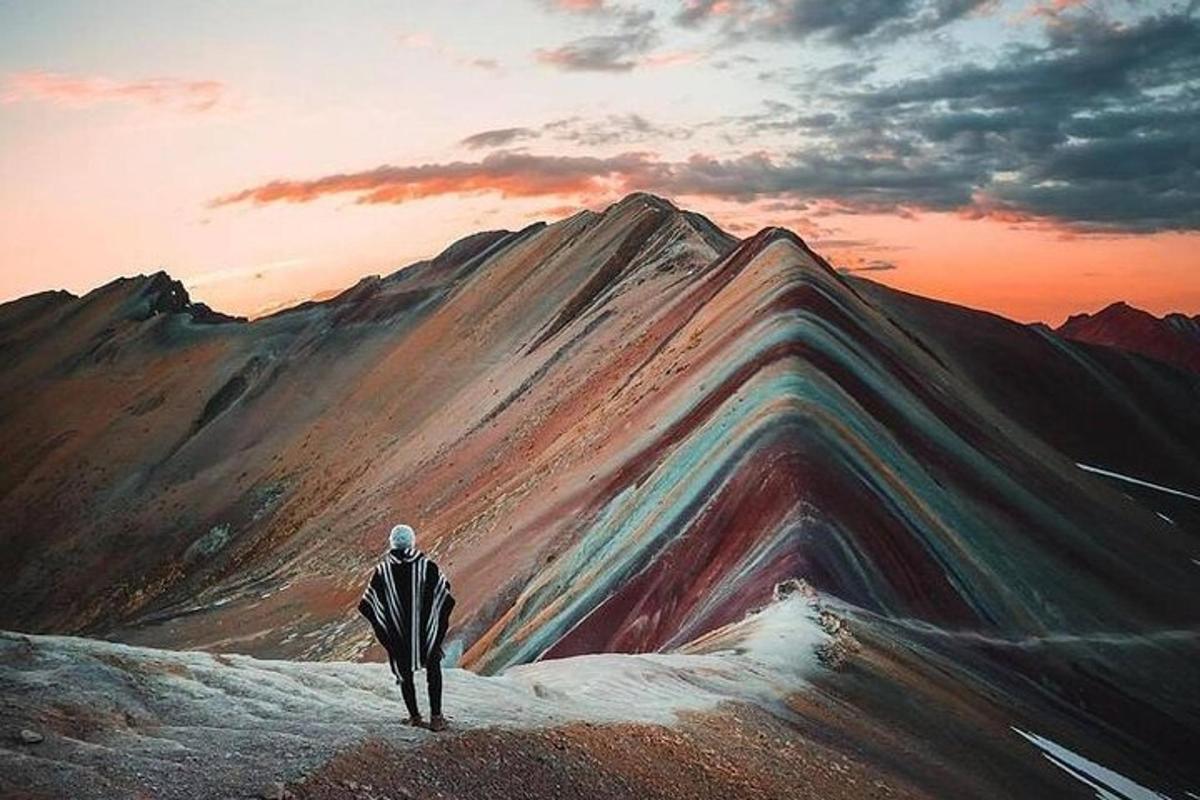 ein Gemälde eines Mannes, der auf einem Berggipfel steht