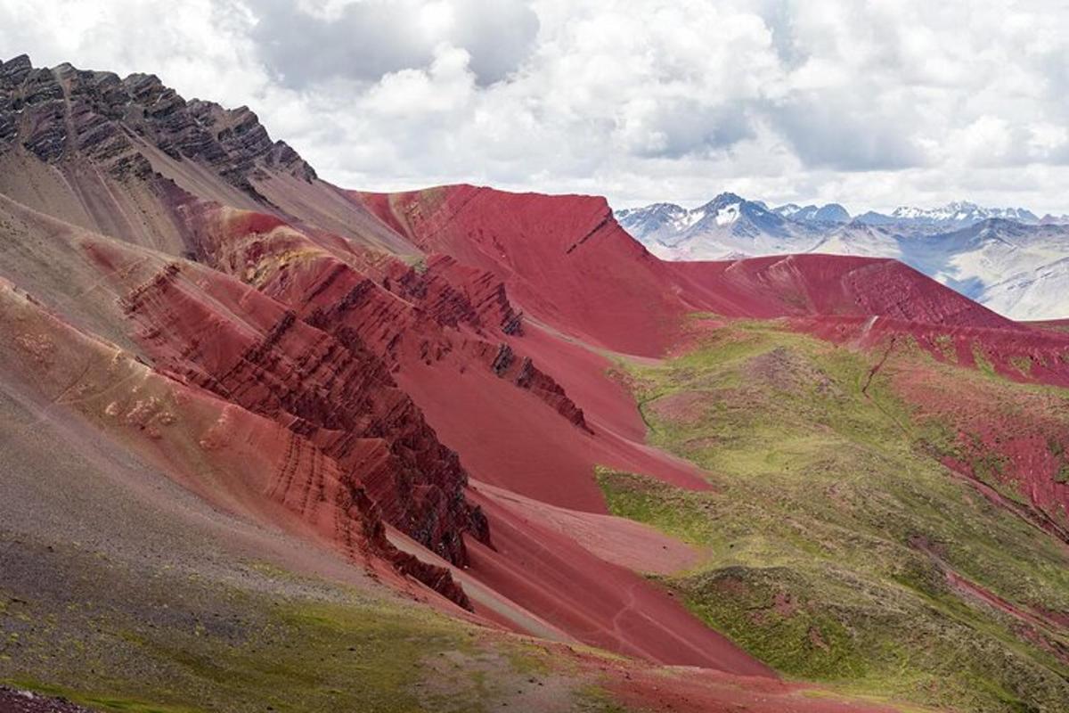 una vista di una montagna rossa con montagne sullo sfondo