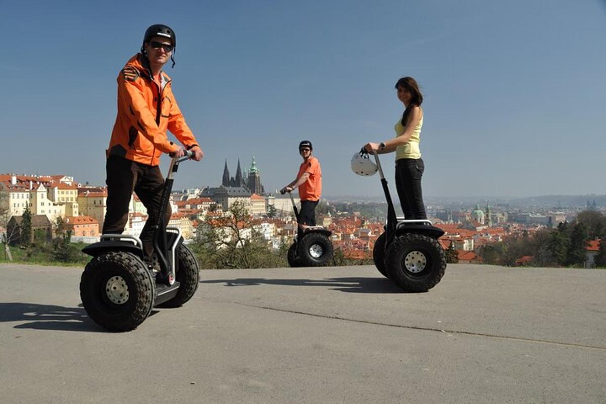 skupina lidí jedoucích na segikách na kopci