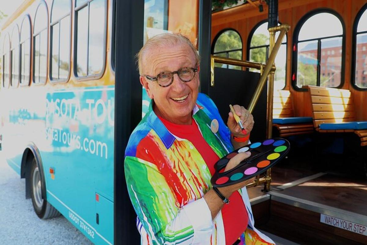 an older man holding a toy in front of a bus