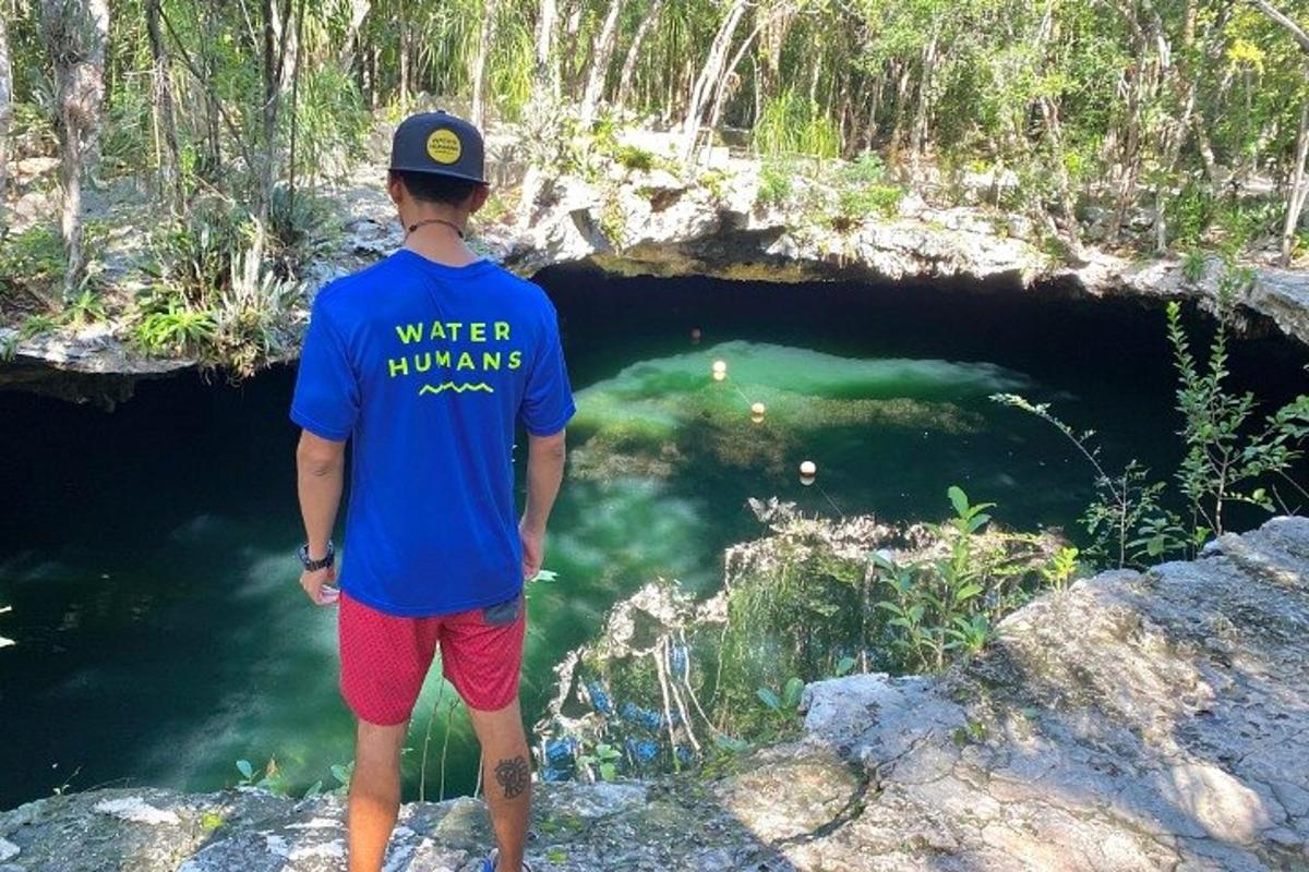 Un hombre está parado frente a una cueva.