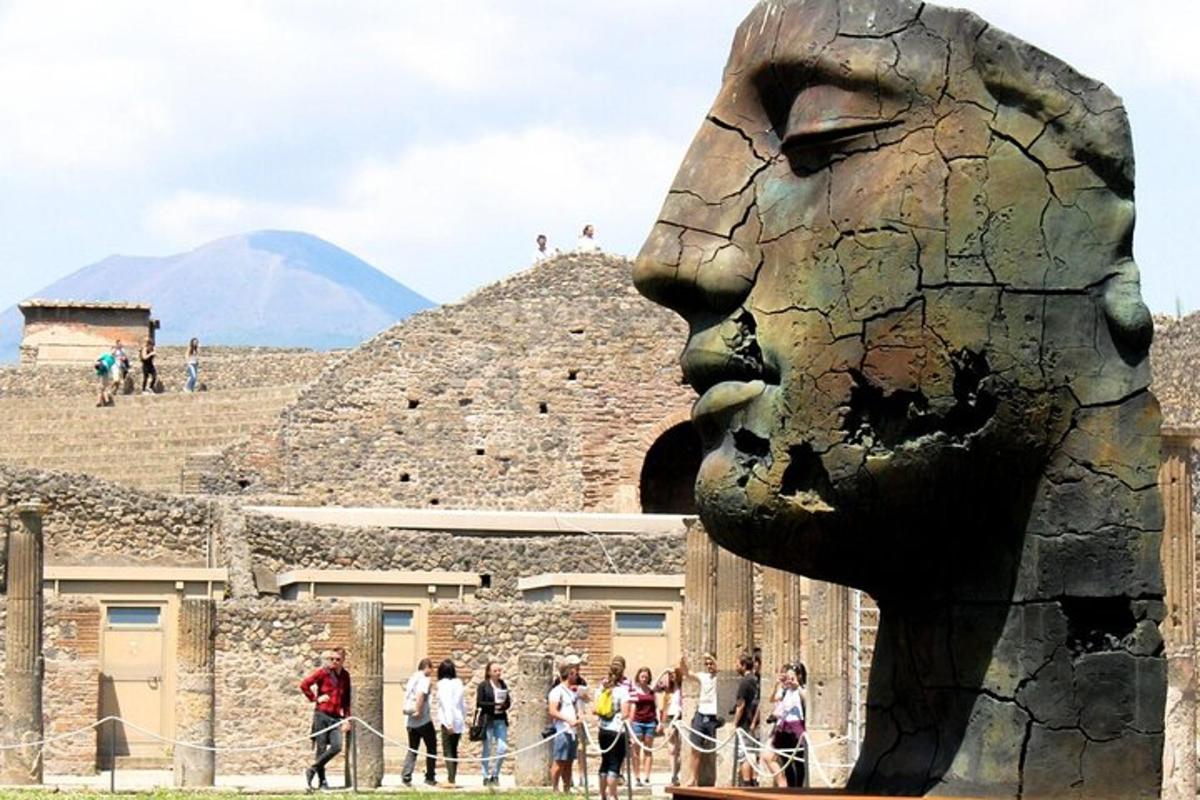 una statua di un volto davanti a una piramide