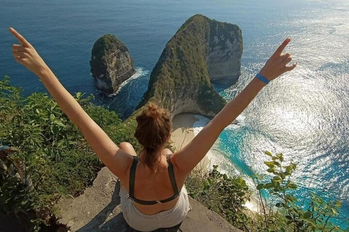 một người phụ nữ đứng trên vách đá với hai tay dang rộng