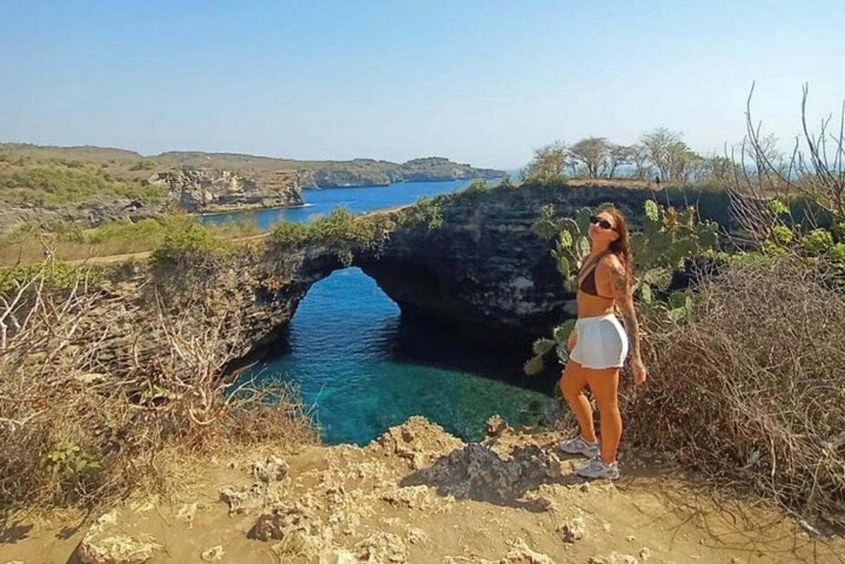 kona stendur fyrir framan helli í vatninu