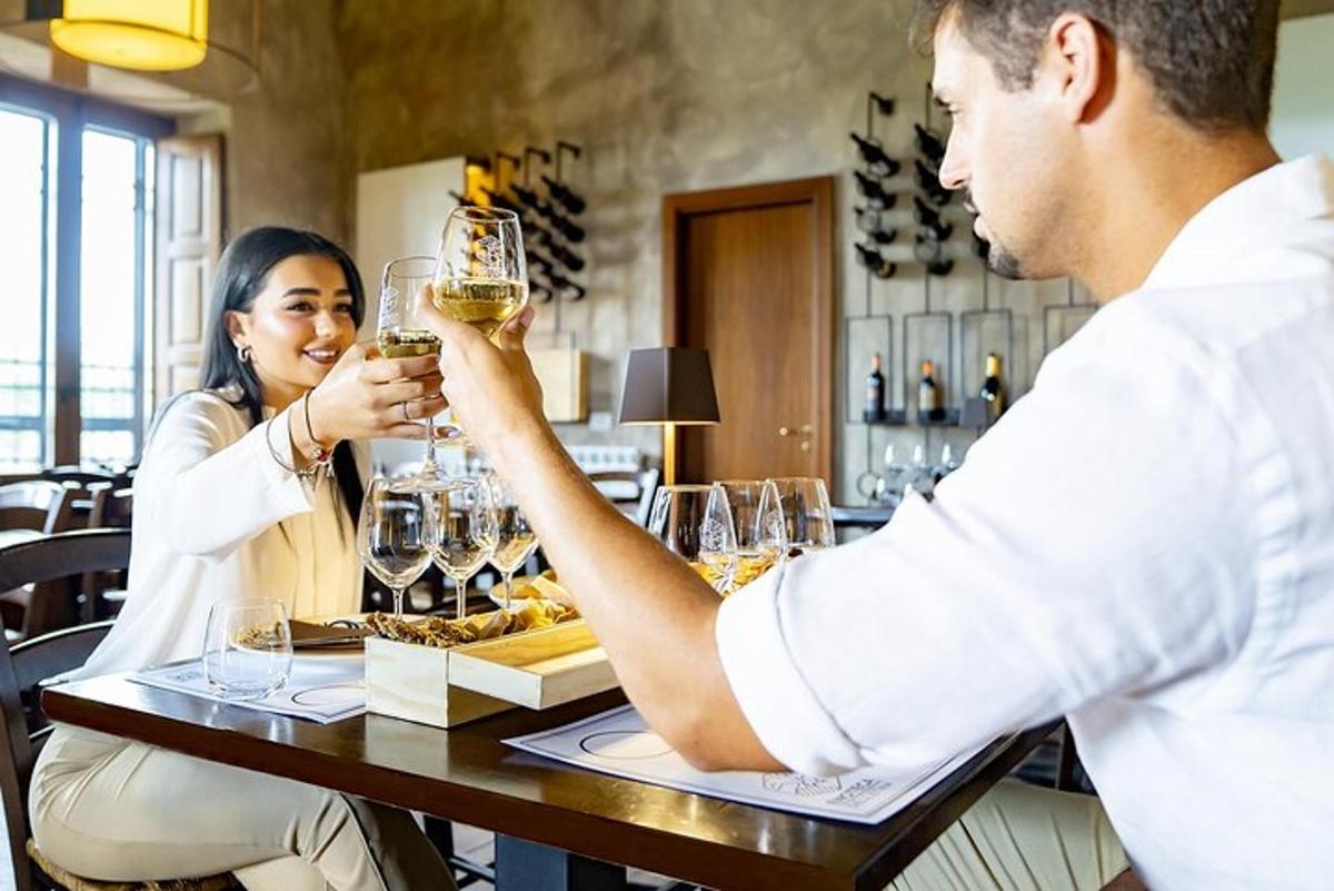 un uomo e una donna seduti a un tavolo con bicchieri di vino