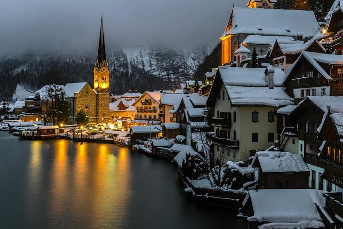 uma cidade coberta de neve com um rio e uma igreja