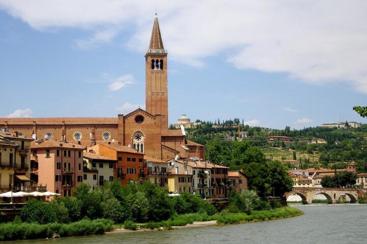 un grande edificio con una torre dell'orologio accanto a un fiume