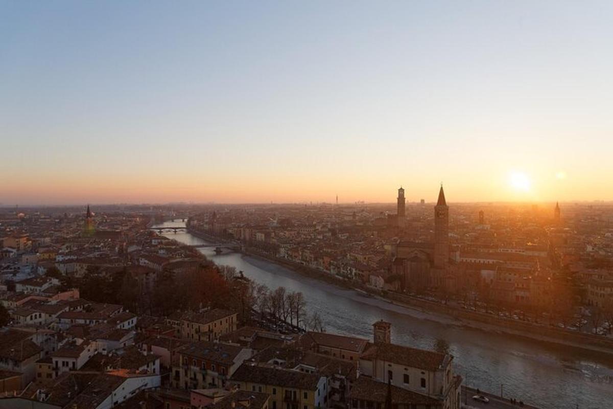 una vista di una città con un fiume e il tramonto