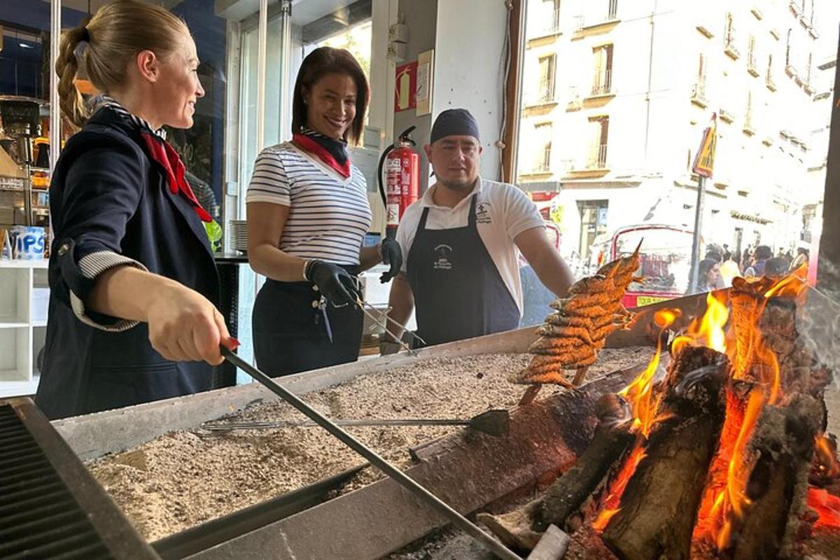 skupina lidí vařících jídlo na grilu