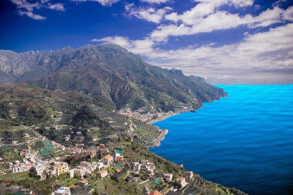 an aerial view of a town on a mountain next to the ocean