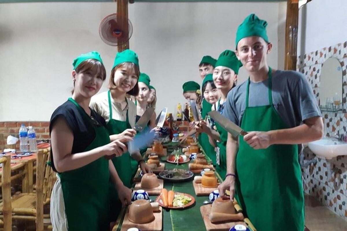 một nhóm người mặc đồng phục màu xanh lá cây đứng quanh một chiếc bàn có đồ ăn