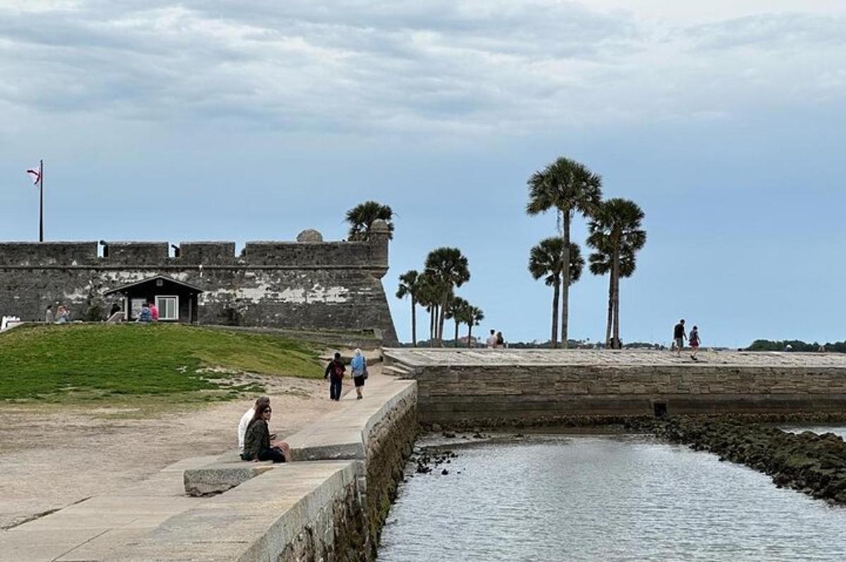 a person sitting on a wall next to a body of water