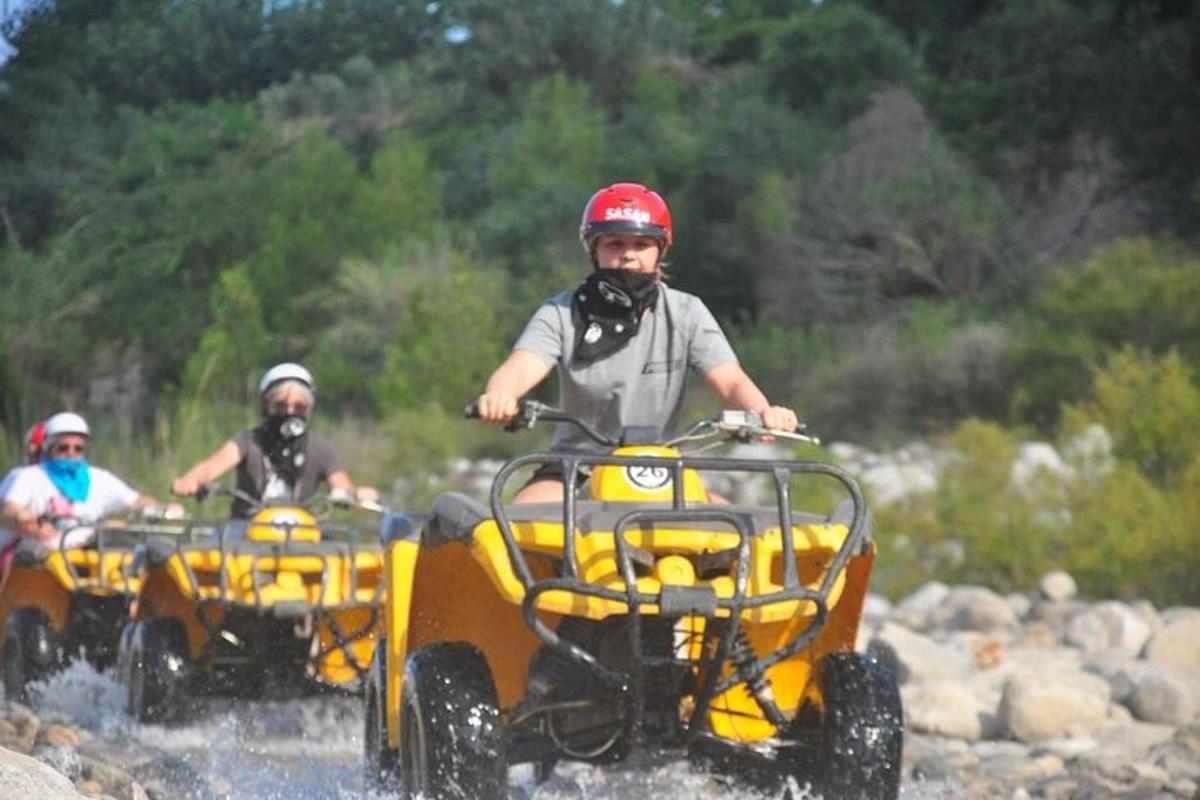 two people riding on atvs in the water