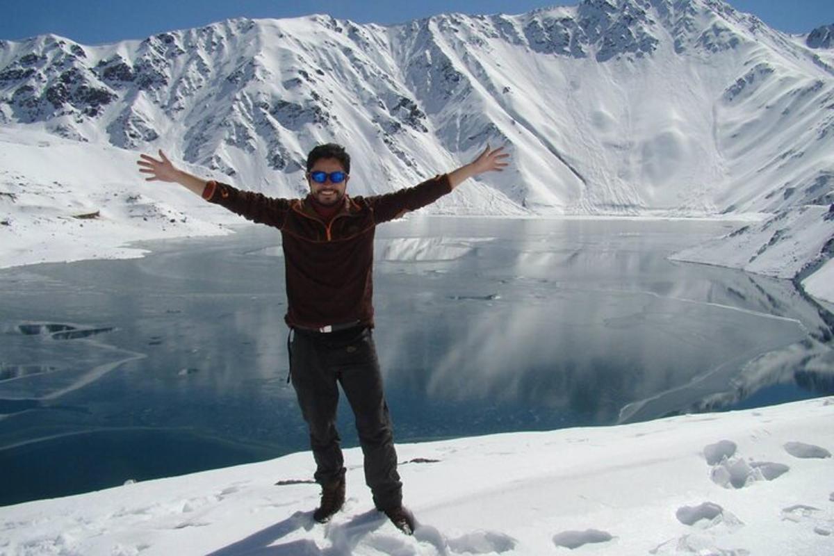 Un hombre parado en la cima de una montaña cubierta de nieve