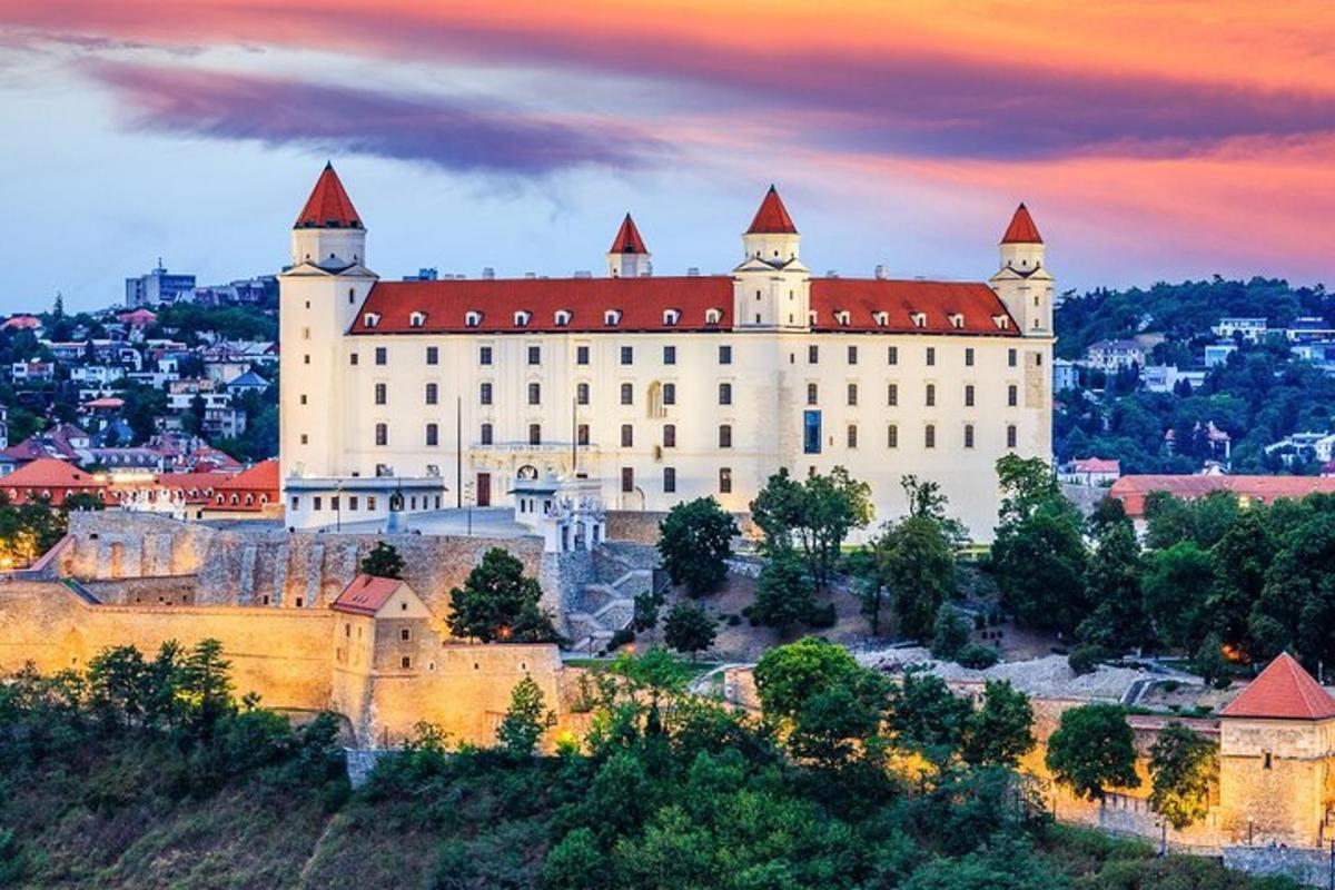 um grande castelo em uma colina com uma cidade ao fundo
