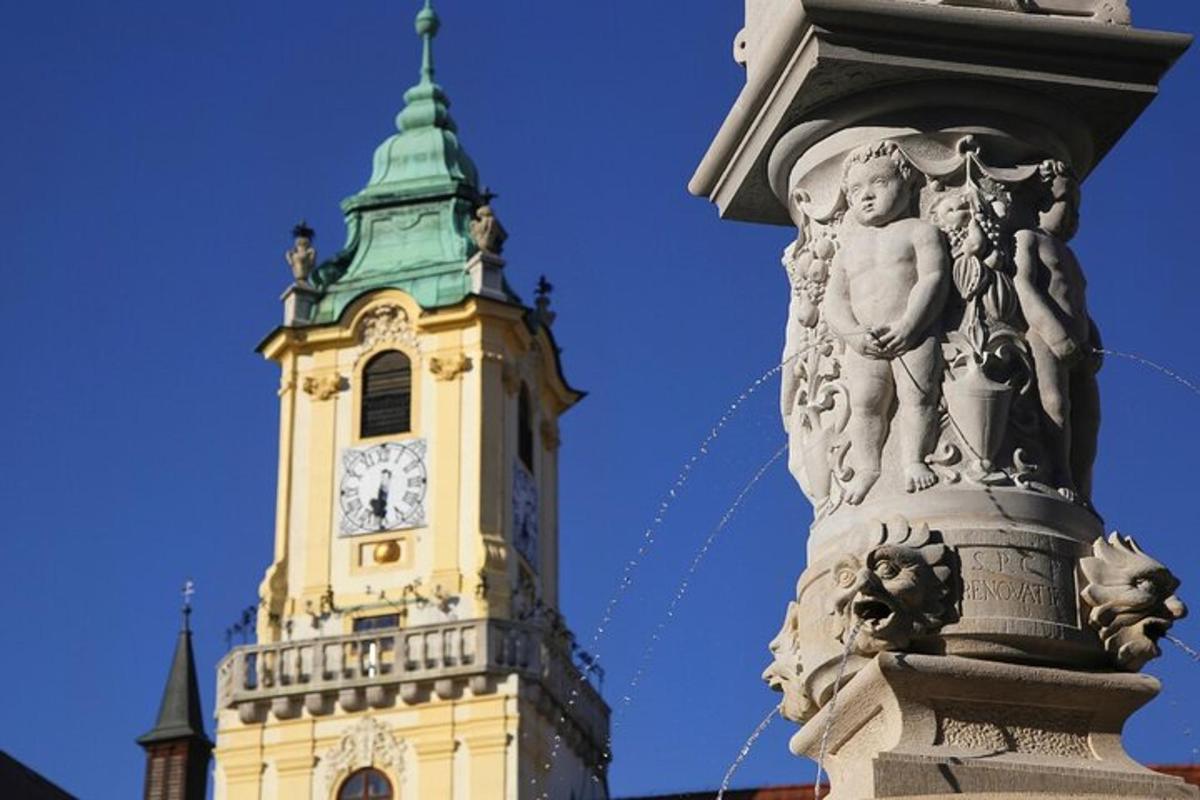 uma torre do relógio com uma estátua em frente a um edifício