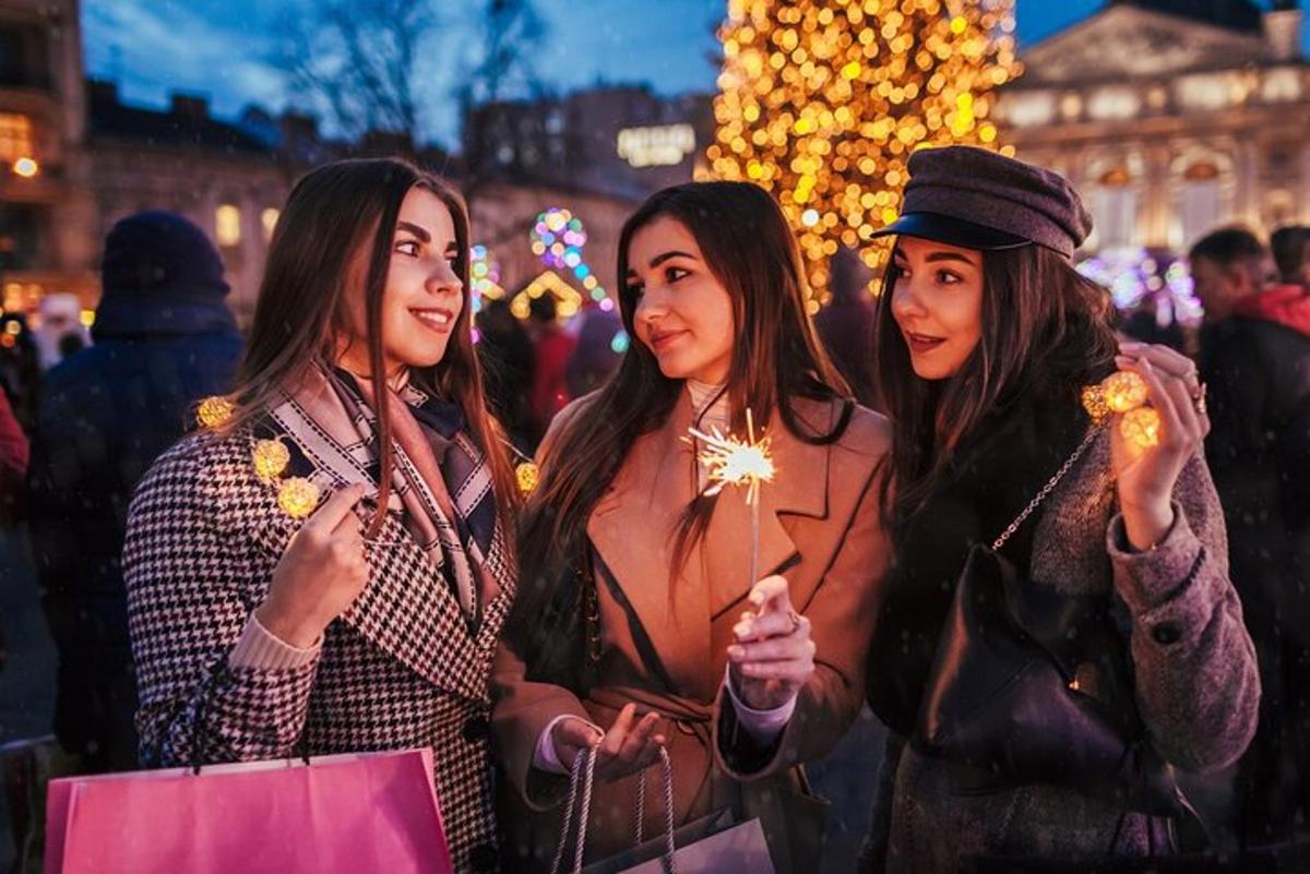 ثلاث نساء يتظاهرن لالتقاط صورة في سوق عيد الميلاد