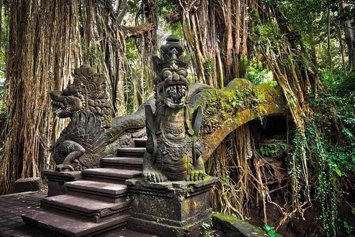 Un puente de piedra con dos estatuas en un bosque.