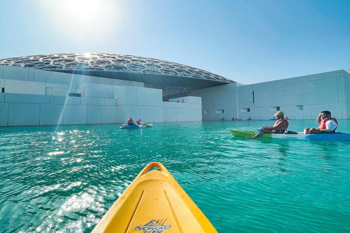 un gruppo di persone sui kayak in acqua vicino a un edificio