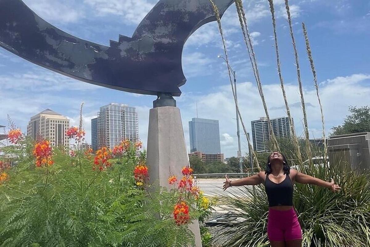 Una mujer parada junto a una estatua de una ballena