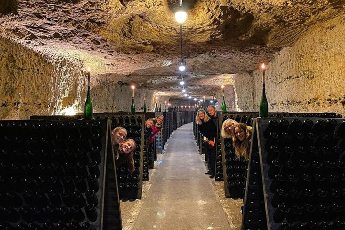a group of people walking down a aisle in a wine cellar