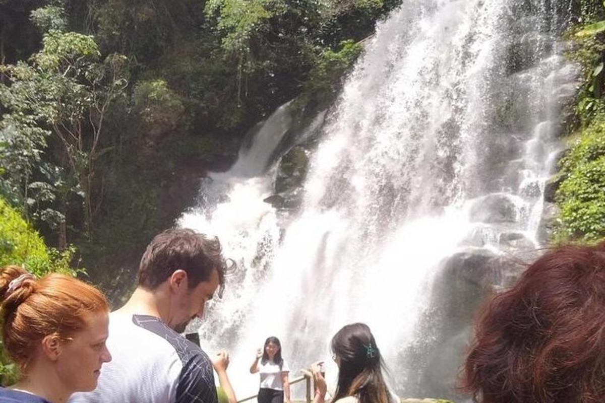 un groupe de personnes debout devant une cascade