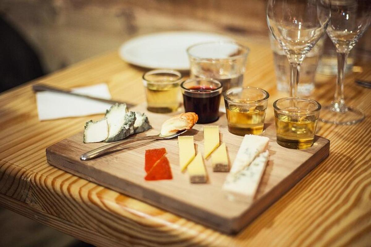 a cutting board with cheese and glasses of wine on a table