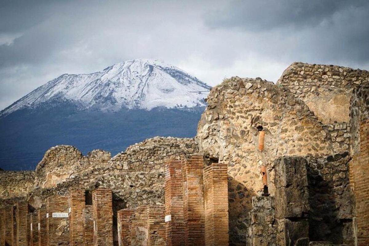 Una montaña cubierta de nieve en la distancia detrás de un edificio antiguo