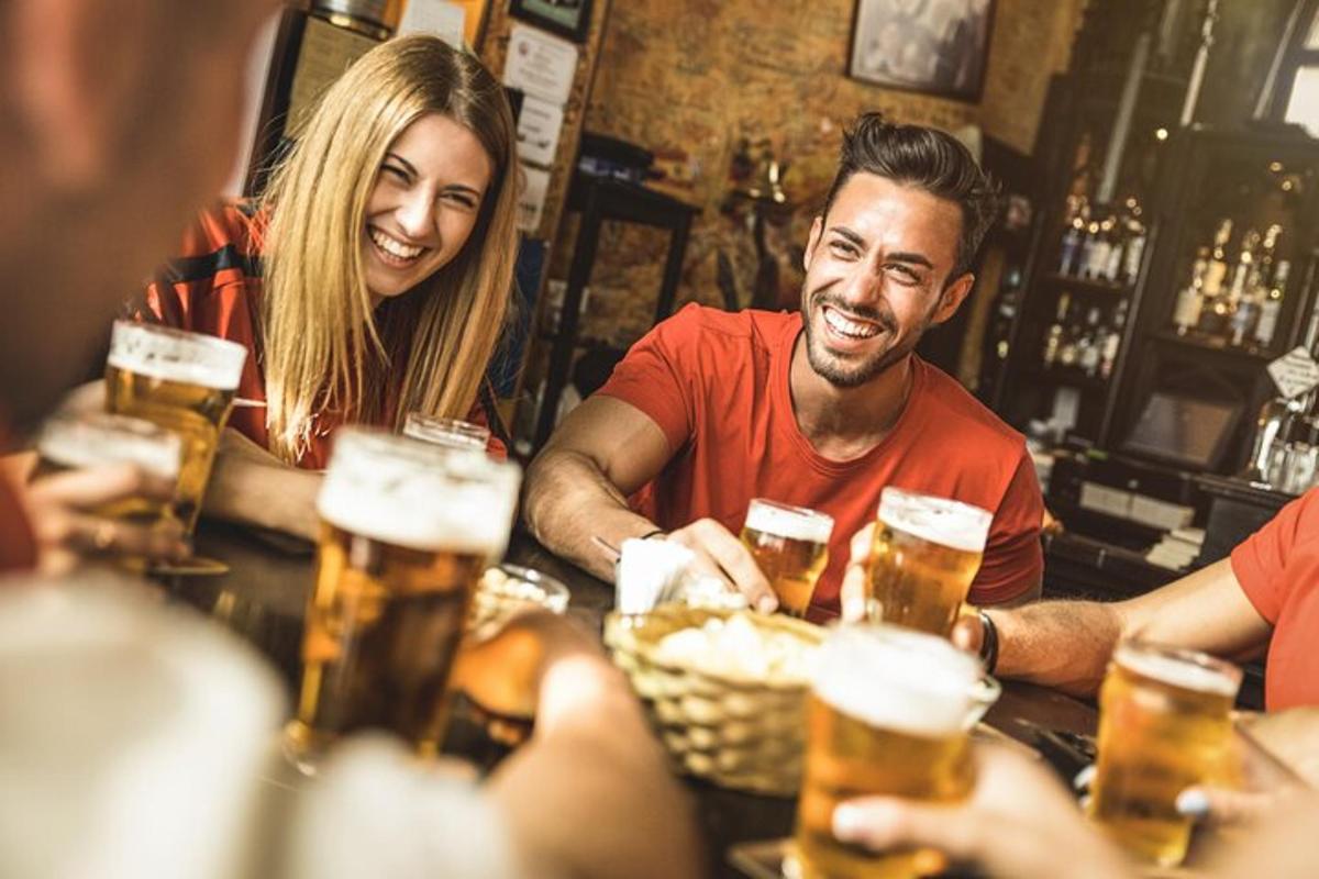 Un grupo de personas sentadas en un bar bebiendo cerveza