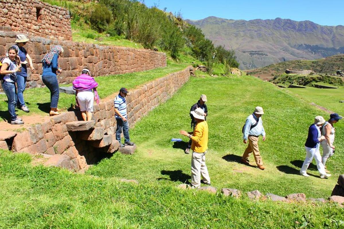 un grup de persones dretes al costat d'un mur de pedra