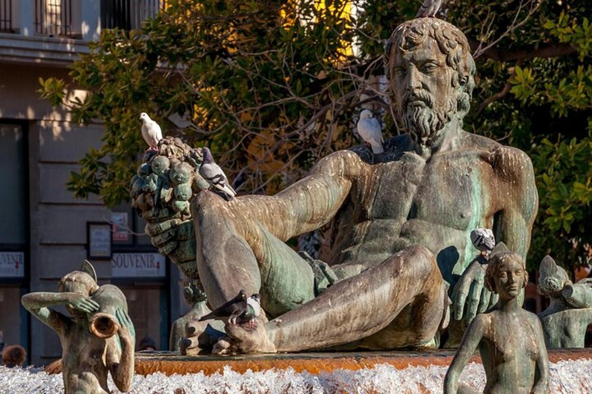 Una estatua de un hombre con palomas en ella