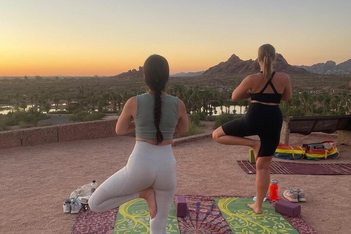 hai người phụ nữ đang tập yoga trên đỉnh núi