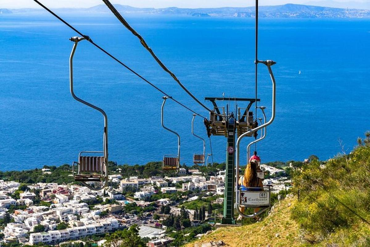 osoba jedoucí na lyžařském vleku nad městem