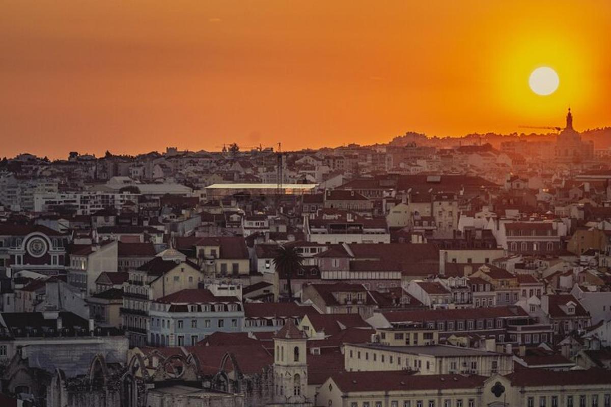 panorama města se zapadajícím sluncem v pozadí