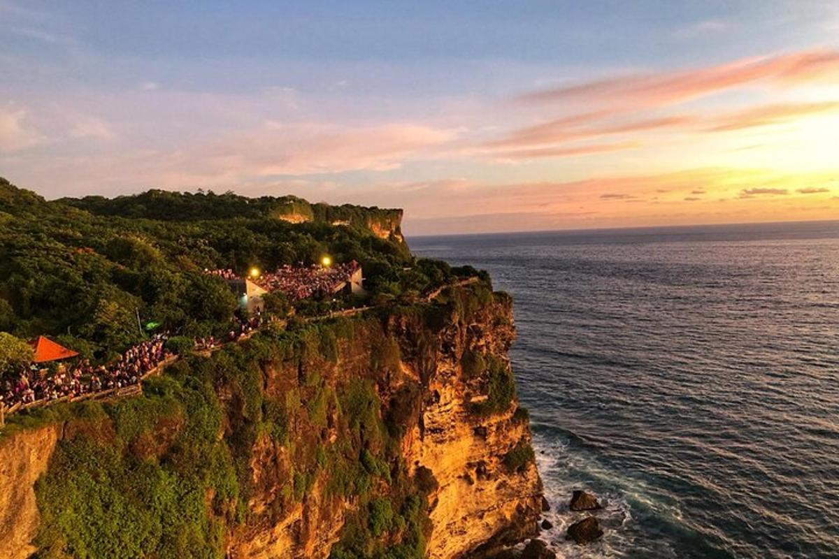 a group of people standing on a cliff near the ocean