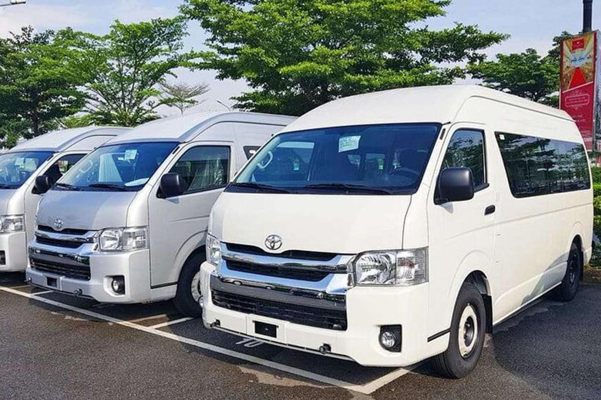sederet mobil van putih terparkir di tempat parkir