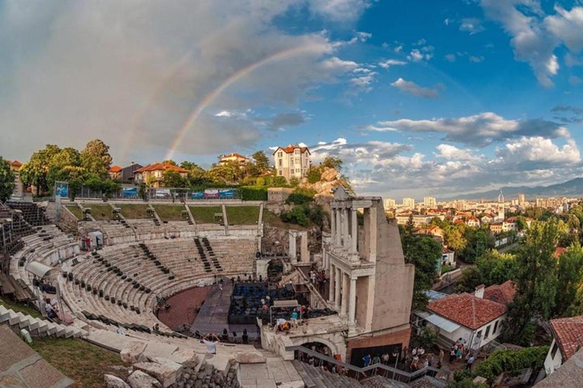 egy amfiteátrum szivárvánnyal a háttérben