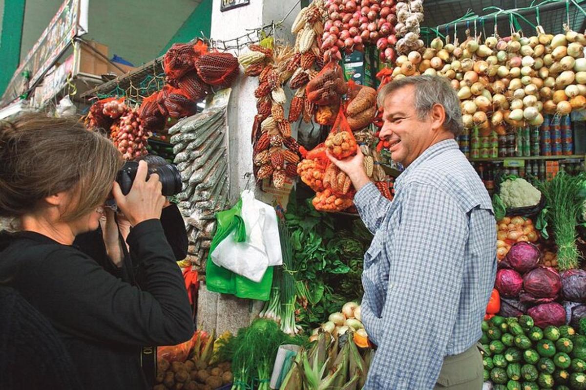 жена фотографише мушкарца на пијаци