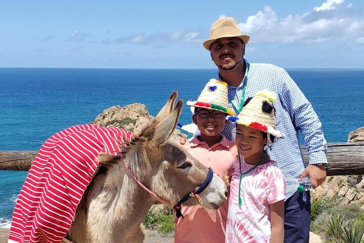 um homem e duas crianças em pé ao lado de um burro