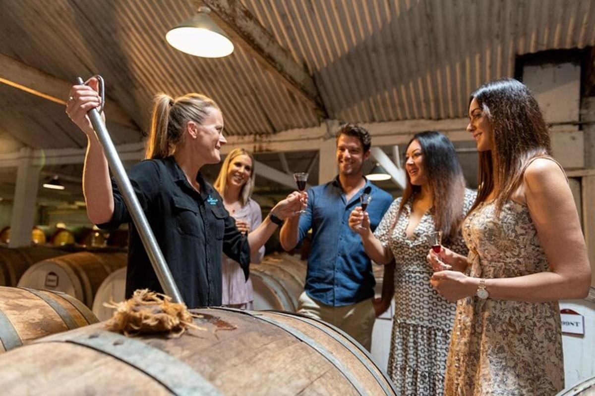 a group of people standing around a wine barrel