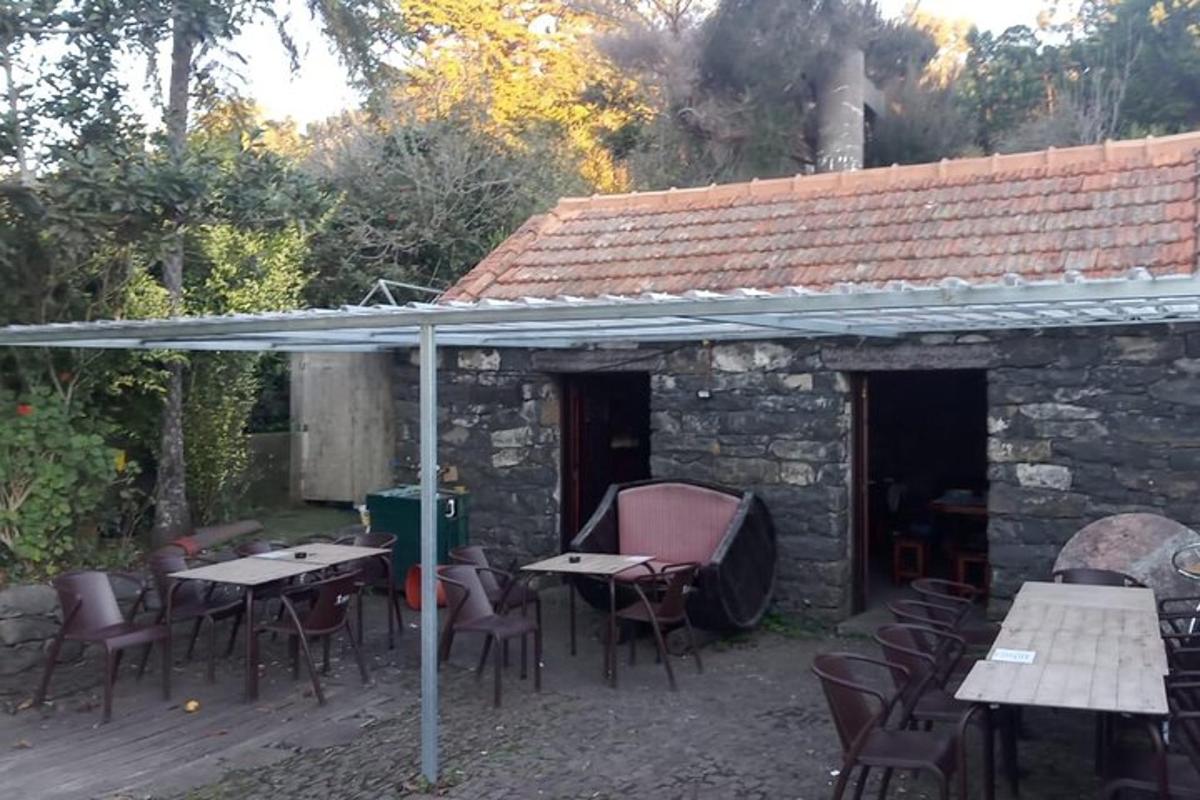 μια βεράντα με τραπέζια και καρέκλες κάτω από μια στέγη