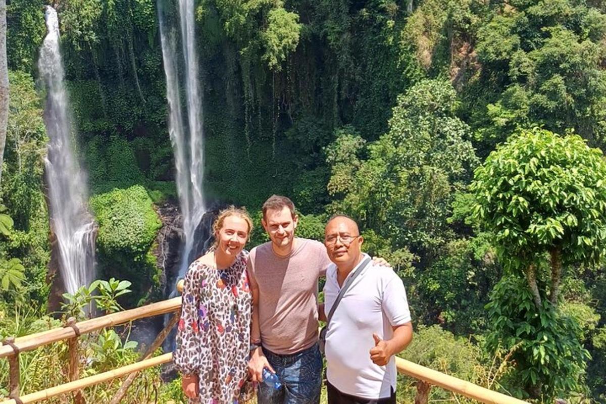 tres personas paradas frente a una cascada