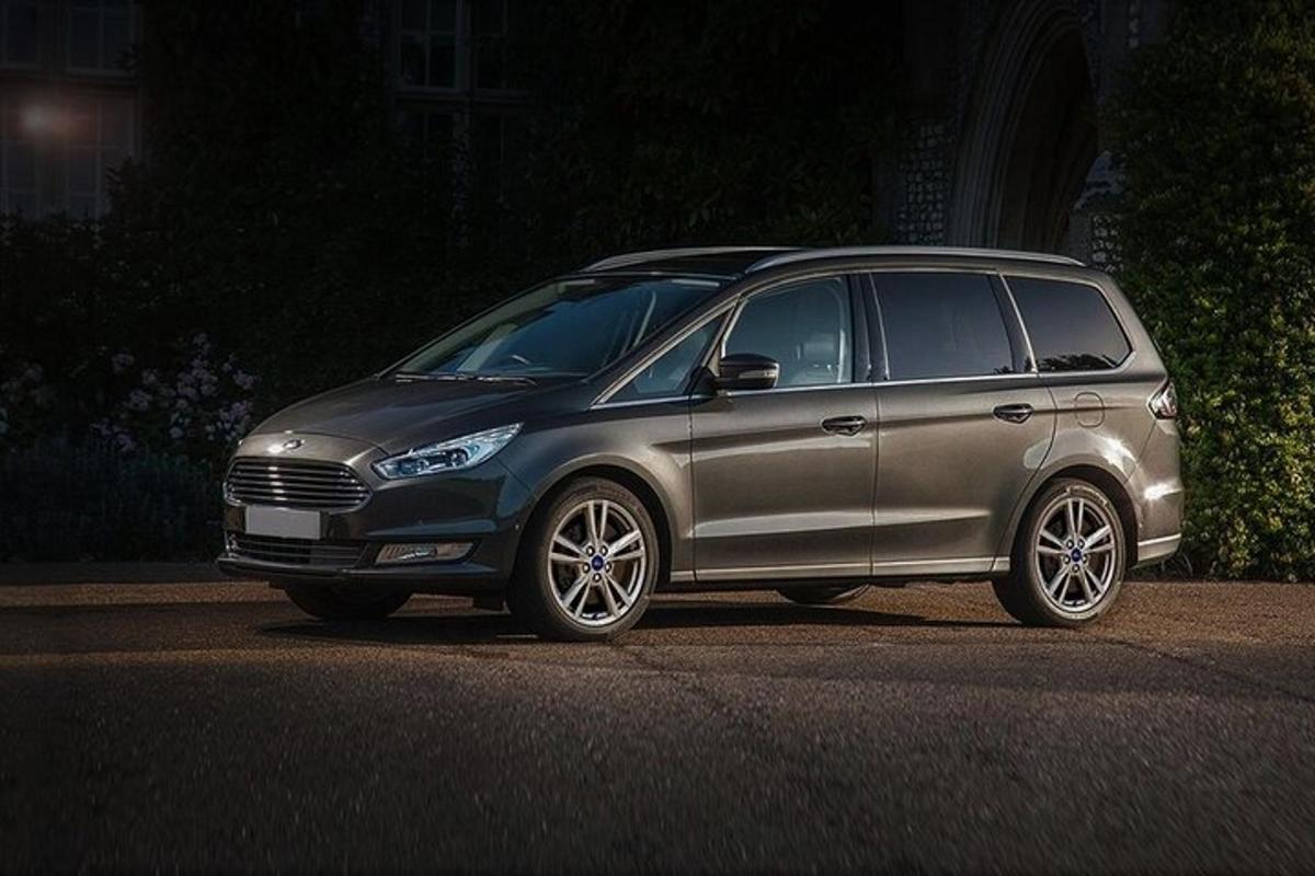 uma minivan prateada estacionada em uma rua à noite