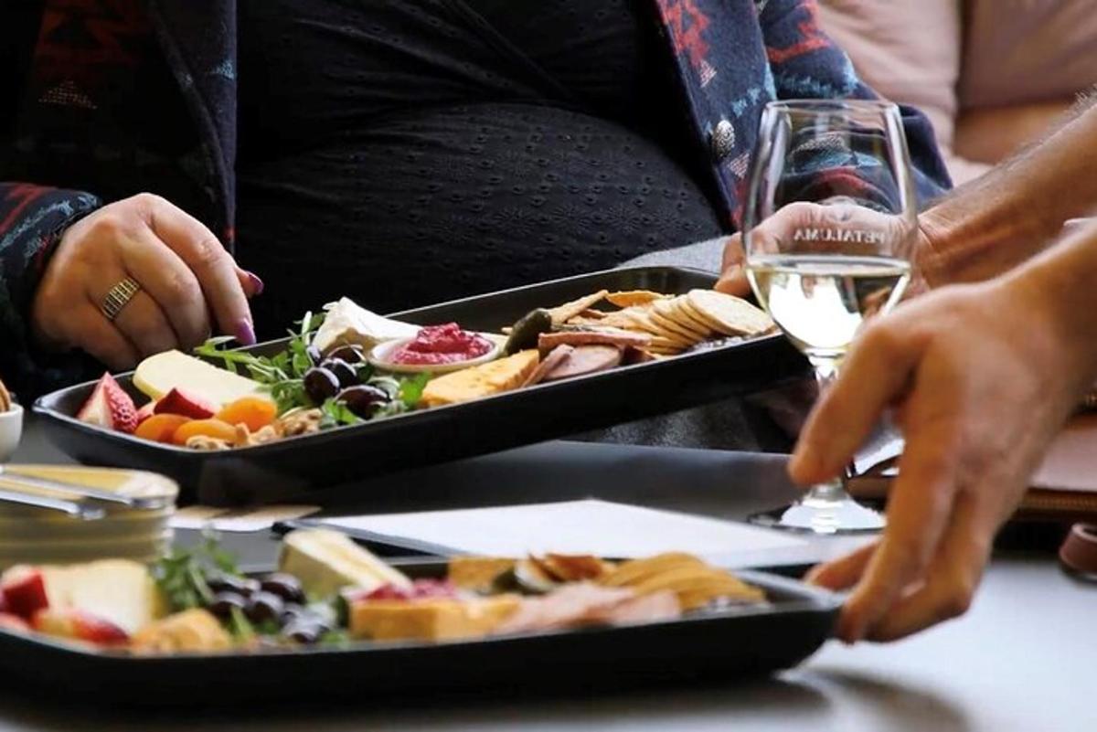 borð með tveimur diskum af mat og glasi af víni