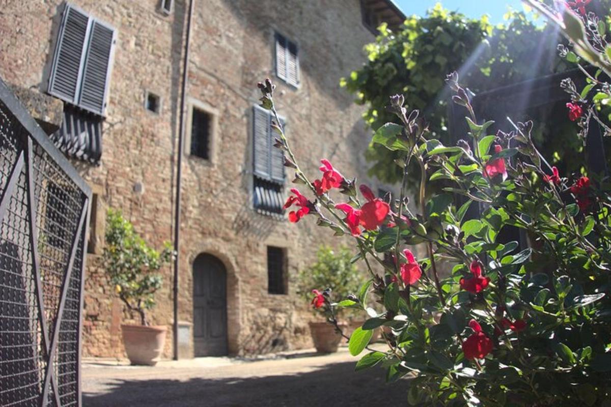a stone building with red flowers in front of it