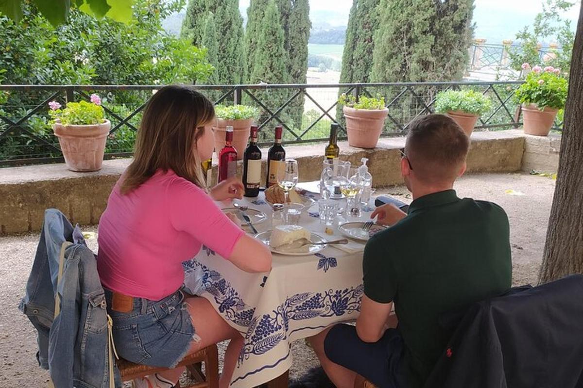 a man and woman sitting at a table with wine bottles