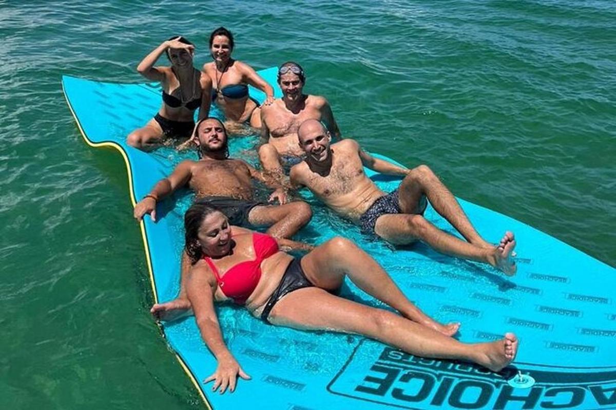 skupina lidí ležících na paddleboardu ve vodě