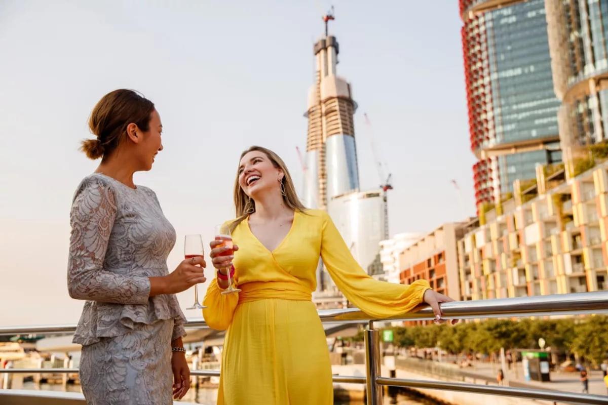 two women standing next to each other in a city