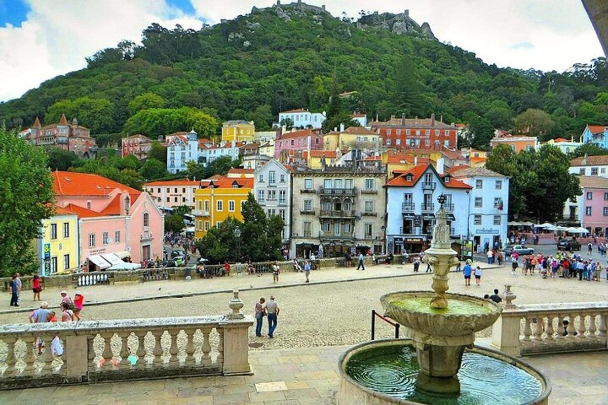 una ciudad con una fuente en frente de un pueblo
